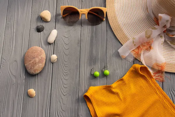 Plaj kadını, şapka çantası güneş gözlüklü çakıl taşları. Yaz arkaplan şablonu boş alan bileşimi örnekleme metni. Ahşap arka plan tatil konseptinin üstündeki üst görünüm