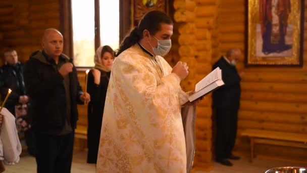 ウクライナのレティシヴ 2020 教会の神の父母の子供を暗示する聖句の儀式の儀式 司祭は聖書を読みました 世界の大災害 コロナウイルス コビド 人々は保護マスクで教皇 — ストック動画