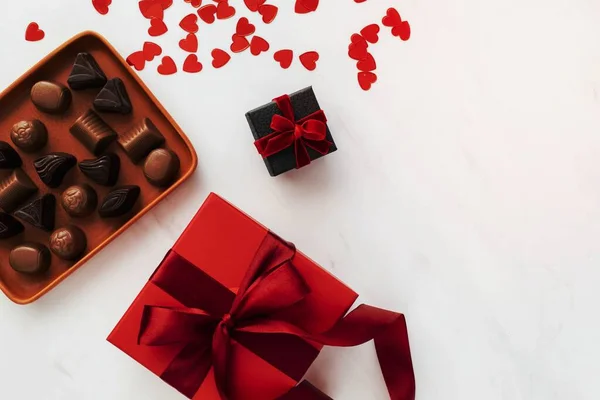 Chocolates by a box of red present