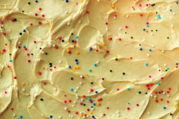 Cake frosting texture background with sprinkles on top