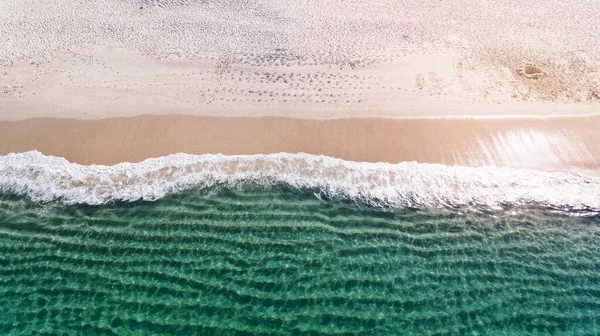Drone view of ocean waves washing on the sand beach at Nelson Bay.