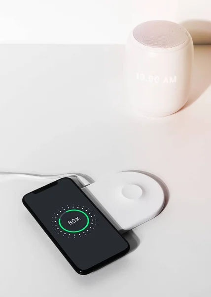 白いワイヤレス充電器パッド上のスマートフォン — ストック写真