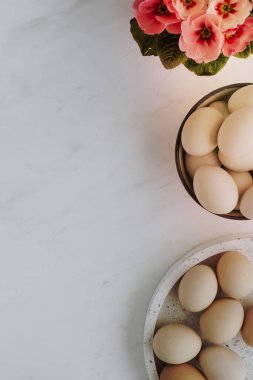 Beyaz mermer masadaki çiğ yumurtaların havadan görünüşü