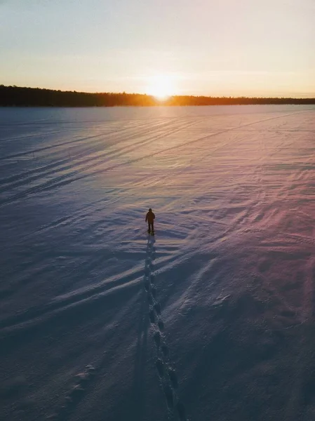 Człowiek Spacerujący Śniegu Podziwiając Zachód Słońca — Zdjęcie stockowe