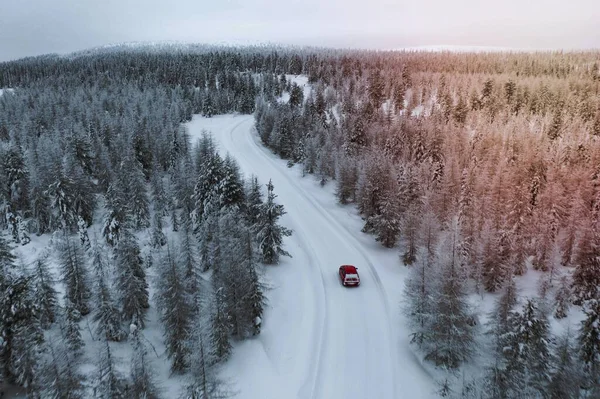 Drone View Red Car Driving Snowy Forest Lapland Finlandia — Zdjęcie stockowe