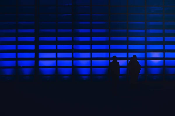 Mavi Işıklı Duvarlı Siluetli Adamlar — Stok fotoğraf