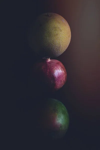 黑暗背景下的三个圆形水果 — 图库照片
