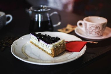 Yanında çay ve haşhaş tohumlu cheesecake.