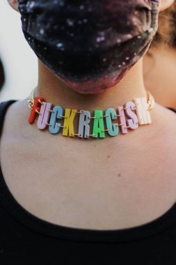 Protester wearing a Fuck Racism necklace at the Black Lives Matter protest in downtown Los Angeles.  8 JUL, 2020, LOS ANGELES, USA