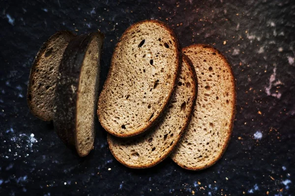 黑色背景小麦面包片 — 图库照片
