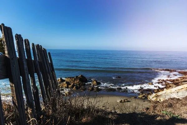 岩の多いビーチによる木製の柵 — ストック写真