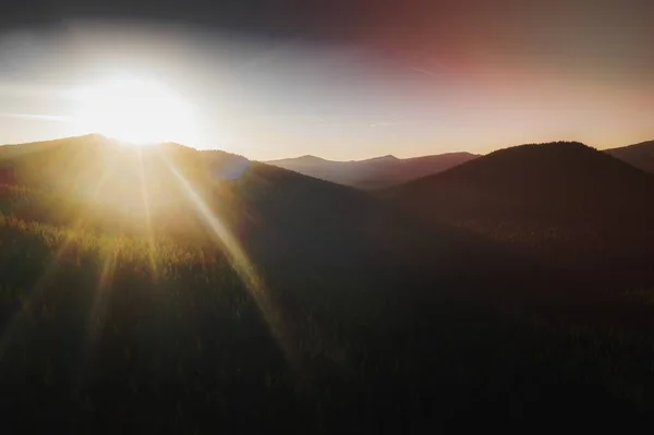 stock image Sunbeam over a top of green mountains