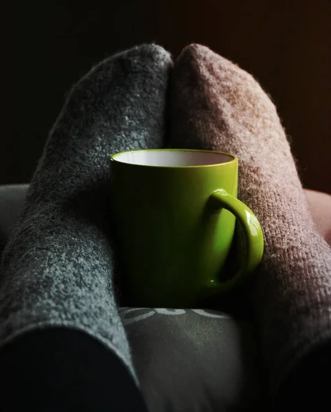 人の足に緑のセラミックマグカップ — ストック写真