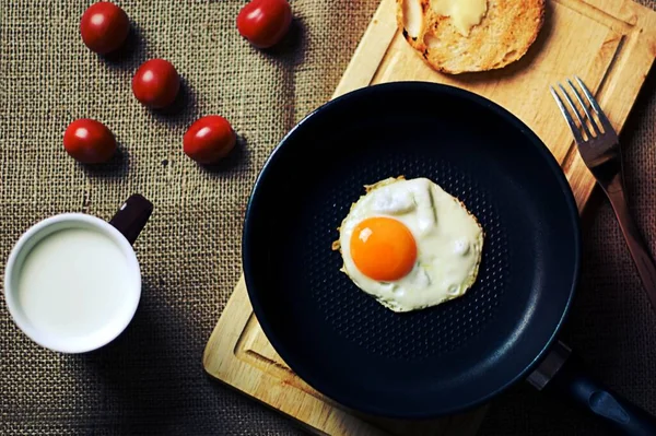 Πρωινό Αυγά Τηγάνι Ξύλο Κοπής Ψωμί Πιρούνι Φαγητό Φλιτζάνι Γάλα — Φωτογραφία Αρχείου