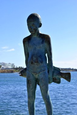 A child holding a fish statue