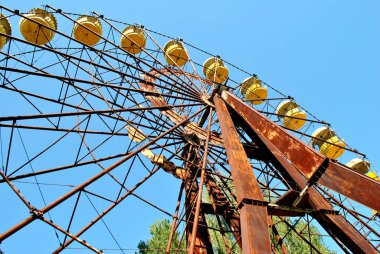 old rusty metal wheel on a background of blue sky