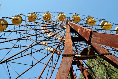 old rusty metal wheel on a background of blue sky