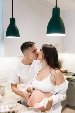 Evde, mutfakta, yatakta, pencerenin yanında ve banyoda, dişlerini fırçalarken, ellerini karnına koyup, un parçasından cheesecake yaparken,