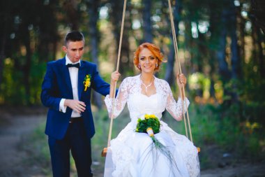 Mavi takım elbiseli, beyaz elbiseli ve buketli güzel bir çift.