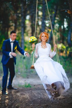 Mavi takım elbiseli, beyaz elbiseli ve buketli güzel bir çift.