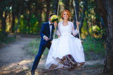 Mavi takım elbiseli, beyaz elbiseli ve buketli güzel bir çift.