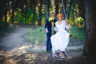 Mavi takım elbiseli, beyaz elbiseli ve buketli güzel bir çift.