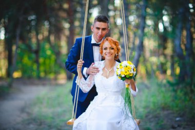 Mavi takım elbiseli, beyaz elbiseli ve buketli güzel bir çift.