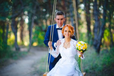 Mavi takım elbiseli, beyaz elbiseli ve buketli güzel bir çift.