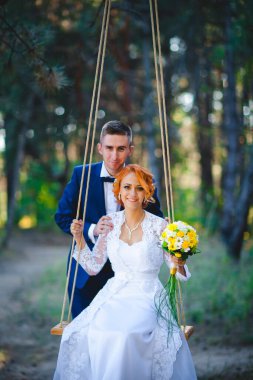 Mavi takım elbiseli, beyaz elbiseli ve buketli güzel bir çift.