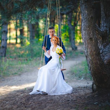Mavi takım elbiseli, beyaz elbiseli ve buketli güzel bir çift.