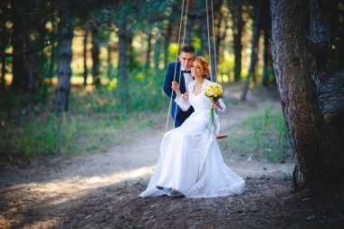 Mavi takım elbiseli, beyaz elbiseli ve buketli güzel bir çift.