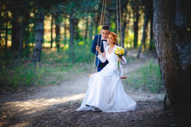 Mavi takım elbiseli, beyaz elbiseli ve buketli güzel bir çift.