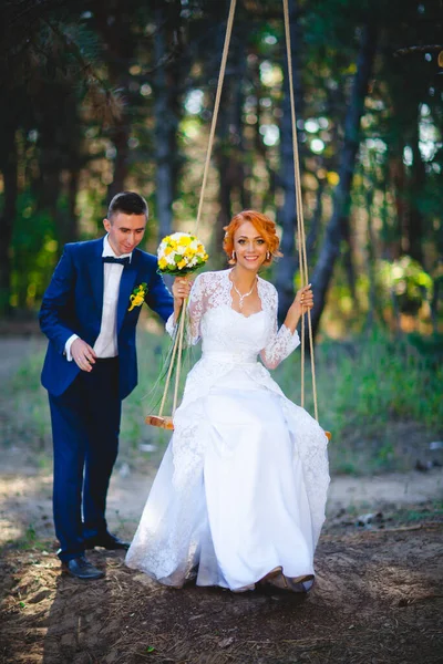 ブルーのスーツを着た若い美しいカップルと花束付きの白いウェディングドレス — ストック写真