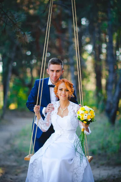 Mavi takım elbiseli, beyaz elbiseli ve buketli güzel bir çift.