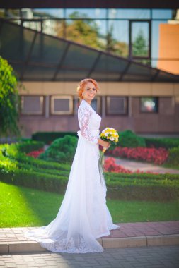 Mavi takım elbiseli, beyaz gelinlikli ve otelde buketi olan genç ve güzel bir çift.