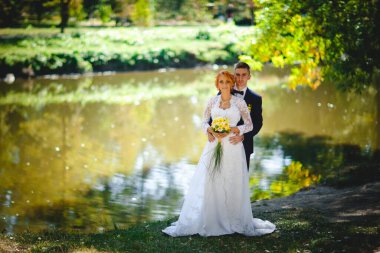 Mavi takım elbiseli, beyaz elbiseli ve buketli güzel bir çift.