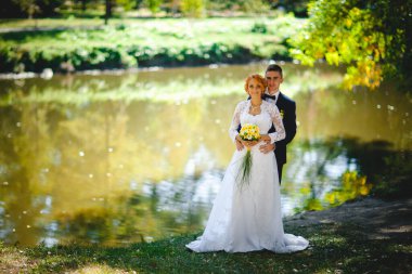 Mavi takım elbiseli, beyaz elbiseli ve buketli güzel bir çift.