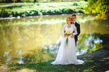 Mavi takım elbiseli, beyaz elbiseli ve buketli güzel bir çift.