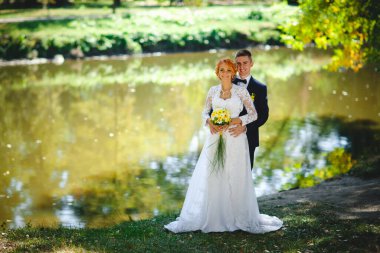 Mavi takım elbiseli, beyaz elbiseli ve buketli güzel bir çift.