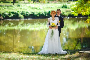 Mavi takım elbiseli, beyaz elbiseli ve buketli güzel bir çift.