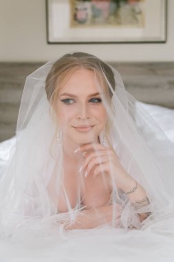 Güzelim, seksi bir gelinin iç çamaşırlı bir buketle sabah hazırlıkları. Bir otelde bornoz. Gelinlik giyip ayakkabılarını giydiği yer.