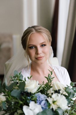 Güzelim, seksi bir gelinin iç çamaşırlı bir buketle sabah hazırlıkları. Bir otelde bornoz. Gelinlik giyip ayakkabılarını giydiği yer.