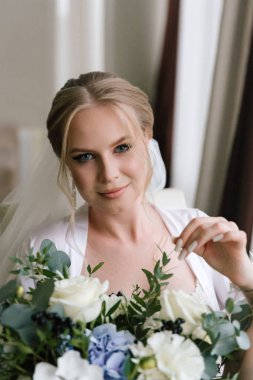 Güzelim, seksi bir gelinin iç çamaşırlı bir buketle sabah hazırlıkları. Bir otelde bornoz. Gelinlik giyip ayakkabılarını giydiği yer.