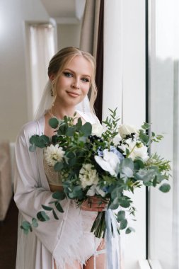 Güzelim, seksi bir gelinin iç çamaşırlı bir buketle sabah hazırlıkları. Bir otelde bornoz. Gelinlik giyip ayakkabılarını giydiği yer.