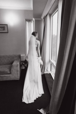 Güzelim, seksi bir gelinin iç çamaşırlı bir buketle sabah hazırlıkları. Bir otelde bornoz. Gelinlik giyip ayakkabılarını giydiği yer.