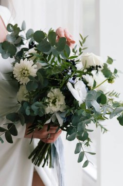 Güzelim, seksi bir gelinin iç çamaşırlı bir buketle sabah hazırlıkları. Bir otelde bornoz. Gelinlik giyip ayakkabılarını giydiği yer.