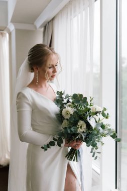 Güzelim, seksi bir gelinin iç çamaşırlı bir buketle sabah hazırlıkları. Bir otelde bornoz. Gelinlik giyip ayakkabılarını giydiği yer.