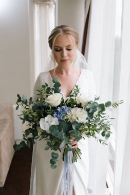 Güzelim, seksi bir gelinin iç çamaşırlı bir buketle sabah hazırlıkları. Bir otelde bornoz. Gelinlik giyip ayakkabılarını giydiği yer.