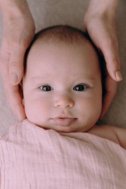 Anne yeni doğmuş bir bebeği besler, bebek bezli bir kızı kollarına alır, anne sarılır ve öper ve bebek gülümser..