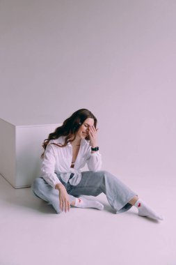 Güzel makyajlı, saç stili olan, kalıcı makyaj uzmanı, elinde aletler tutan lüks bir kız. Fotoğraf stüdyosunda takım elbiseli, kot pantolonlu ve gömlekli bir fotoğrafçı..